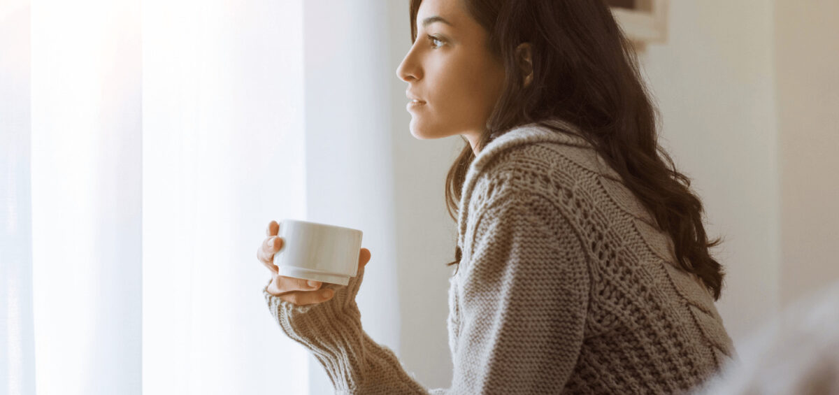 woman thinking and holding coffee